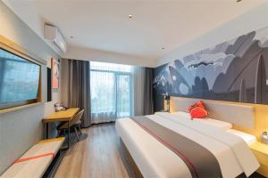 a hotel room with a large bed and a desk at Thank Inn Shaoxing Luxun Hometown in Shaoxing