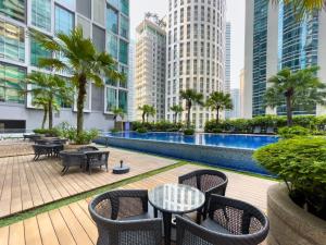 Soho Suites KLCC by Wakely Kuala Lumpur في كوالالمبور: فناء في الهواء الطلق مع طاولات وكراسي ومباني