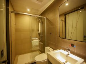 a bathroom with a sink and a toilet and a mirror at Thank Inn Plus Beijing Yizhuang Maju Bridge Jinghai Road in Tongzhou