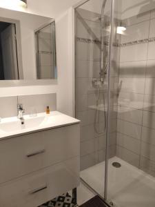 een witte badkamer met een douche en een wastafel bij Panissac in Berneuil