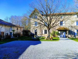 a large stone house with a tree in front of it at Panissac in Berneuil