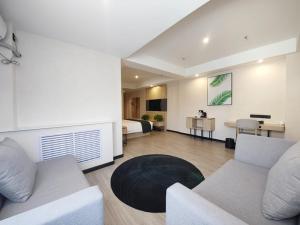 a living room with a couch and a bed at Thank Inn Plus Lanzhou Dongfanghong Plaza Pingliang Road in Lanzhou