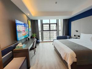 a hotel room with a bed and a flat screen tv at Thank Inn Plus Hanzhong High-Speed Railway Station in Hanzhong