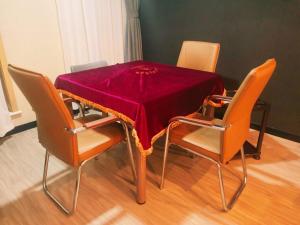 stół z krzesłami i czerwoną tkaniną w obiekcie Thank Inn Zaozhuang Tengzhou Jinghe Road Zhenai Mall w mieście Tengzhou