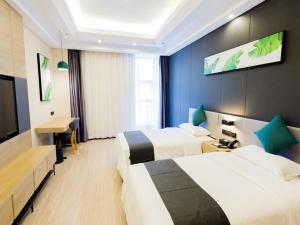 una camera d'albergo con due letti e una scrivania di Thank Inn Plus Datong Senyuan Building High-Speed Railway Station a Datong
