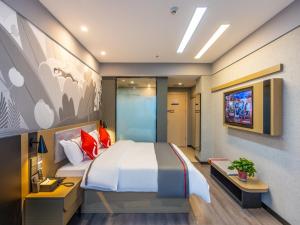 1 dormitorio con 1 cama grande y TV en Thank Inn Plus Linxia Bafang Shisanxiang, en Linxia