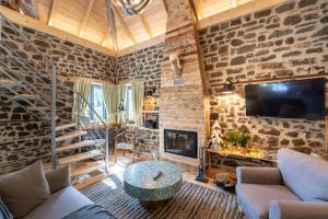 sala de estar con paredes de piedra y chimenea en Dandy Villas Karpenisi - Lux Chalet en Áyios Nikólaos