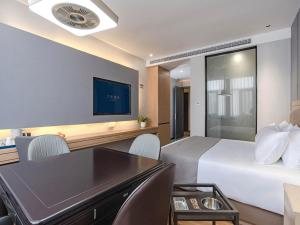 潛江的住宿－潜江高铁站龙虾城兰欧酒店，酒店客房设有一张大床和一张书桌。
