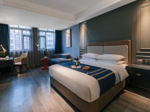 万州にあるLanOu Hotel Chongqing Hongou Square Wanzhou Guanyinyanの大きなベッドとデスクが備わるホテルルームです。