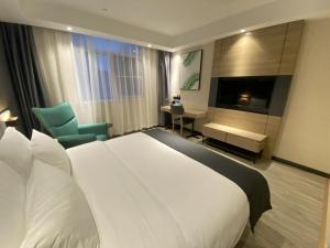 um quarto de hotel com uma grande cama branca e uma secretária em Thank Inn Plus Yancheng Sheyang Dayang Road em Sheyang