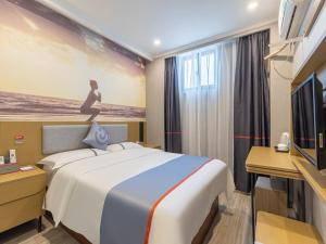 a hotel room with a bed and a painting on the wall at Junyi Hotel Hefei South High-Speed Railway Station in Hefei