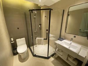 a bathroom with a shower and a toilet and a sink at Thank Inn Plus Yancheng Sheyang Dayang Road in Sheyang