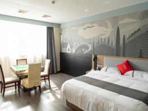1 dormitorio con cama, mesa y escritorio en Thank Inn Plus Nanchang Longhu Paradise Street, en Nanchang