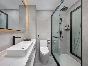 a bathroom with a toilet and a sink and a shower at Thank Inn Plus Dongguan Dalingshan in Dongguan