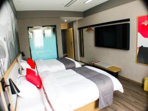 Cette chambre comprend 2 lits et une télévision à écran plat. dans l'établissement Thank Inn Plus Chuzhou Mingguang Starlight Trade City, à Mingguang