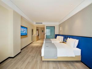um grande quarto de hotel com duas camas e uma televisão em LanOu Hotel Taikoo Li Night Market Kuqa City em Kuqa