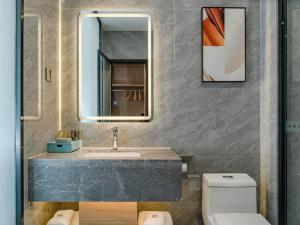 潛江的住宿－潜江高铁站龙虾城兰欧酒店，一间带水槽、镜子和卫生间的浴室