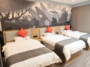 Habitación de hotel con 3 camas con almohadas de color naranja en Thank Inn Plus Nanchang Longhu Paradise Street, en Nanchang