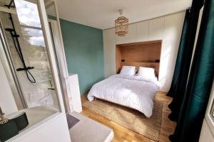 sypialnia z łóżkiem i szklanymi drzwiami w obiekcie Les Jardins de Rosie 