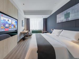 臨沂にあるThank Inn Linyi Jiaxing Fruit Marketの大型ベッド1台、薄型テレビが備わるホテルルームです。