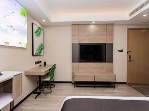 a hotel room with a tv and a desk and a bed at Thank Inn Plus Xuzhou Yunchuang Technology Park Ocean Polar World in Xuzhou