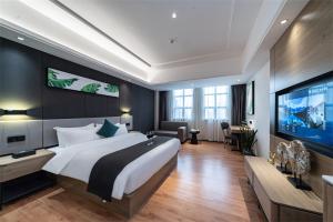 ein Schlafzimmer mit einem großen Bett und einem Flachbild-TV in der Unterkunft Thank Inn Plus Chaozhou Caitang Lotus in Xialian