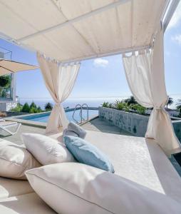 a group of pillows on a patio with a pool at Casa el Goce - Luxury Villa, private pool, BBQ and bathtub in Tijarafe