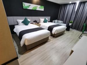 um quarto de hotel com duas camas num quarto em Thank Inn Plus Aksu Kuqa Xingfu Road em Kuqa