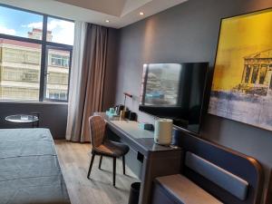 日喀則的住宿－日喀则龙江路兰欧酒店，一间卧室配有一张桌子、一台电脑和一张床