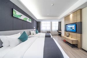 ein großes Schlafzimmer mit einem großen Bett und einem Flachbild-TV in der Unterkunft Thank Inn Plus Chaozhou Caitang Lotus in Xialian
