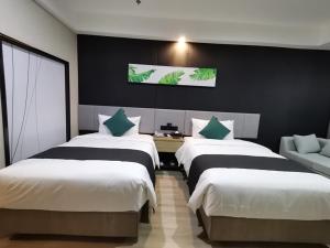 um quarto de hotel com três camas e um sofá em Thank Inn Plus Aksu Kuqa Xingfu Road em Kuqa
