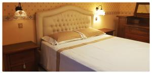 a bedroom with a white bed and two night stands at Dream of Chantal in Casal Palocco