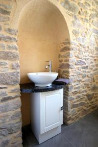 a bathroom with a sink and a stone wall at Les chambaudies in Château-Chervix
