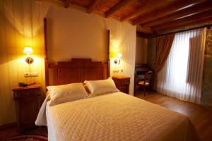 a bedroom with a white bed with two pillows at Hotel Vila do Val in Ferreira