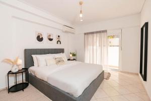 een slaapkamer met een groot wit bed en een raam bij Phaedrus Living: Cozy Flat Koukaki in Athene