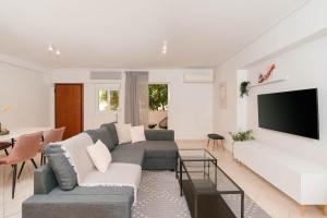 een woonkamer met een bank en een flatscreen-tv bij Phaedrus Living: Cozy Flat Koukaki in Athene