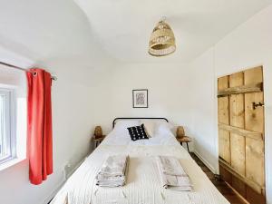um quarto com uma cama branca e uma cortina vermelha em Laburnum No3 by Oracle em Stratford-upon-Avon