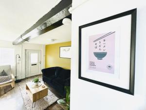 亞芬河畔史特拉福的住宿－Laburnum No3 by Oracle，客厅配有黑色沙发和图片