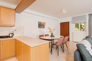een keuken en woonkamer met een tafel en stoelen bij Phaedrus Living: Cozy Flat Koukaki in Athene +7 foto's