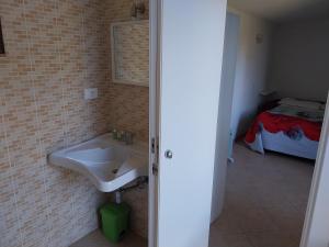 ein Bad mit einem Waschbecken und ein Bett in einem Zimmer in der Unterkunft Agriturismo Santa Chiara in Pomarance