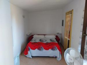 1 dormitorio con 1 cama con manta roja en Agriturismo Santa Chiara, en Pomarance