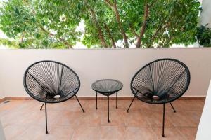 een paar stoelen naast een muur bij Phaedrus Living: Cozy Flat Koukaki in Athene