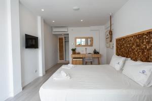 a bedroom with a large white bed with white shoes on it at Blue Harbour Boutique in Ayia Napa