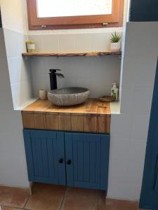 uma casa de banho com um lavatório num balcão de madeira em Au Petit Faubourg em Grignan