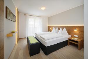 a hotel room with a bed and a table at Hotel Garni Paler in Tirolo +35 photos