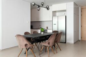 une salle à manger avec une table et des chaises noires dans l'établissement The Address Beach Residences - 2BR & Private Beach, à Dubaï
