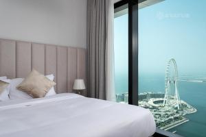 The Address Beach Residences - 2BR & Private Beach في دبي: غرفة في الفندق مع سرير وإطلالة على الملاهي الدوارة