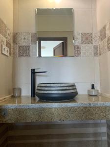 ein Bad mit einem Waschbecken und einem Spiegel in der Unterkunft Vitál Guesthouse in Almamellék
