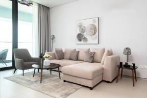 The Address Beach Residences - 2BR & Private Beach في دبي: غرفة معيشة مع أريكة وطاولة