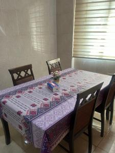 una mesa con un edredón en la parte superior con sillas en Nice Suites & Hotels, en La Meca